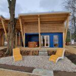 photo presents the sauna building with recreational concrete deckchairs